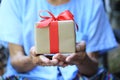 Senior man hands holding gift box with red ribbon for Christmas Royalty Free Stock Photo