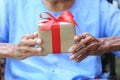 Senior man hands holding gift box with red ribbon for Christmas Royalty Free Stock Photo