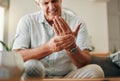 Senior man, hands and wrist joint pain in living room home from carpal tunnel, osteoporosis and arthritis. Elderly, sick