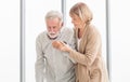 Senior man is having back pain and his attractive old woman supports him. Elderly man suffering from back pain and takes care by Royalty Free Stock Photo