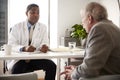 Senior Man Having Consultation With Male Doctor In Hospital Office Royalty Free Stock Photo