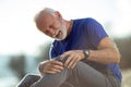 Senior man having a knee pain after workout in nature selective focus Royalty Free Stock Photo