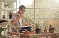 Senior man having morning coffee while reading newspaper in his houseplant garden home. retirement lifestyle Royalty Free Stock Photo