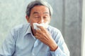 Senior man having sickness and sneezing into tissue, Healthcare