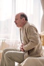 Senior man having stomach pain sitting home Royalty Free Stock Photo