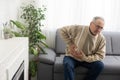 Senior man having stomach pain sitting at home. Royalty Free Stock Photo