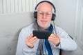 Senior man in headphones listening to music at home Royalty Free Stock Photo