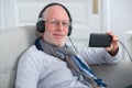 Senior man in headphones listening to music at home Royalty Free Stock Photo