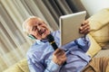 Senior man in headphones singing karaoke, using digital tablet Royalty Free Stock Photo