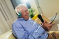 Senior man in headphones singing karaoke, using digital tablet Royalty Free Stock Photo