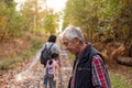 Senior man hiking with his family in autumn forest, shallow depth of field Royalty Free Stock Photo
