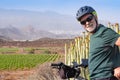 Senior man on his electro bike outdoor. Green vineyard and mountain in background Royalty Free Stock Photo