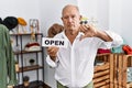 Senior man holding banner with open text at retail shop with angry face, negative sign showing dislike with thumbs down, rejection Royalty Free Stock Photo