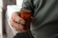 Senior man holding bottle with pills in his hand Royalty Free Stock Photo