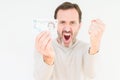 Senior man holding five pounds bank note over isolated background annoyed and frustrated shouting with anger, crazy and yelling