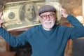 Senior man holding gigantic 100 dollars bill Royalty Free Stock Photo