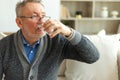 Senior man holding glass drinking fresh water at home. Mature old senior thirsty grandfather takes care of his health