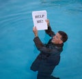 Senior man holding help me paperwork in water