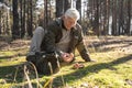 Senior man holding mushrooms in his hands and examining it while sitting Royalty Free Stock Photo