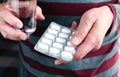 Senior man holding a pack of pills and a glass of water in his hands. Caring for the health of the elderly. Close-up