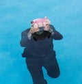 Senior man holding piggy bank above water Royalty Free Stock Photo