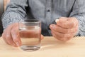 Senior man holding pill and glass of water at table Royalty Free Stock Photo