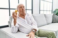 Senior man holding pills making fish face with lips, crazy and comical gesture Royalty Free Stock Photo