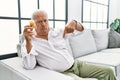 Senior man holding pills pointing down looking sad and upset, indicating direction with fingers, unhappy and depressed Royalty Free Stock Photo