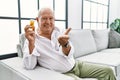 Senior man holding pills smiling cheerful offering palm hand giving assistance and acceptance Royalty Free Stock Photo