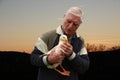 A senior man holding and talking to a duck Royalty Free Stock Photo