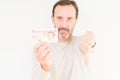 Senior man holding ten pounds bank note over isolated background with angry face, negative sign showing dislike with thumbs down,