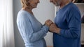 Senior man holding woman hands, looking at each other and smiling, flirting Royalty Free Stock Photo