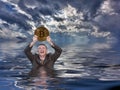 Senior man holds up bitcoin and drowns in ocean Royalty Free Stock Photo