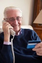 Senior Man At Home Giving Credit Card Details On The Phone Royalty Free Stock Photo