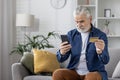 Senior man at home making a payment using smartphone Royalty Free Stock Photo
