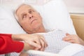 Senior man in hospital bed holding wife's hand Royalty Free Stock Photo