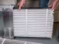 Senior man inserting a new air filter in a HVAC Furnace Royalty Free Stock Photo