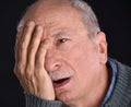 Senior man with irritated red bloodshot eye suffering from pain Royalty Free Stock Photo