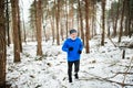 Senior man jogging in woodland in winter nature. Royalty Free Stock Photo