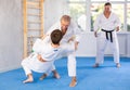 Senior man, karate sensei, engaging kumite with young guy in training room Royalty Free Stock Photo