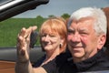 Senior man with keys of the car and his woman in a sports car Royalty Free Stock Photo