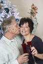 Senior Man Kissing Woman Under Mistletoe