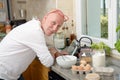 Senior man in kitchen using tablet Royalty Free Stock Photo