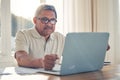 Senior man, laptop and documents in finance or budget planning or checking bills and expenses at home. Mature male Royalty Free Stock Photo