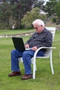 Senior man with laptop at golf