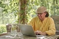 Senior man with laptop outdoors