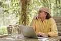 Senior man with laptop outdoors