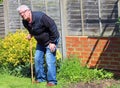 Senior man leaning on waking stick or cane.