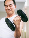 Senior man lifting dumbbell in fitness gym. Royalty Free Stock Photo