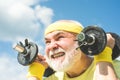 Senior man lifting dumbbell. Senior man in gym working out with weights. Old mature man exercising with dumbbell. Happy Royalty Free Stock Photo